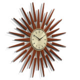 Skewed view of the Pluto sunburst style wall clock by Newgate World with dark wood rays and a gold metal Arabic dial