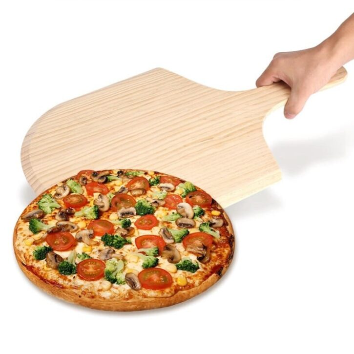 pizza opgediend met pizzaschep op houten dienblad